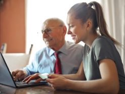 young woman helping senior man with payment on internet 3823488